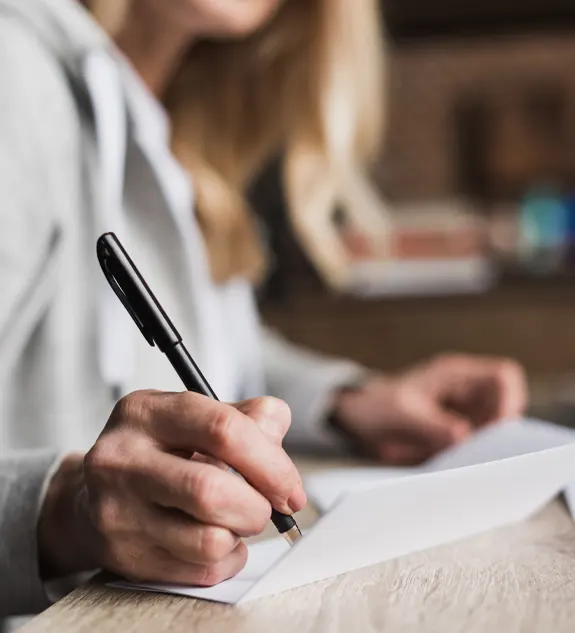 Close Up Partial View of Woman Writing With Pen