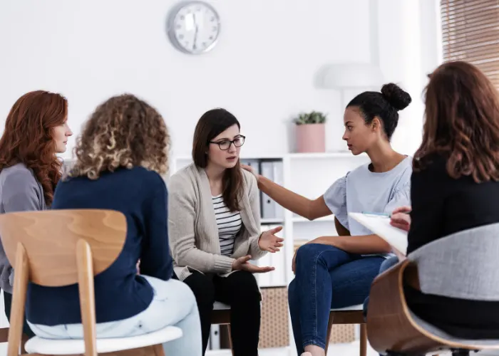 Consulting With Young Woman In Group