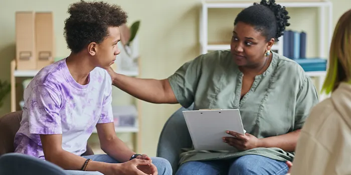 Psychologist Talking To Boy At Consultation